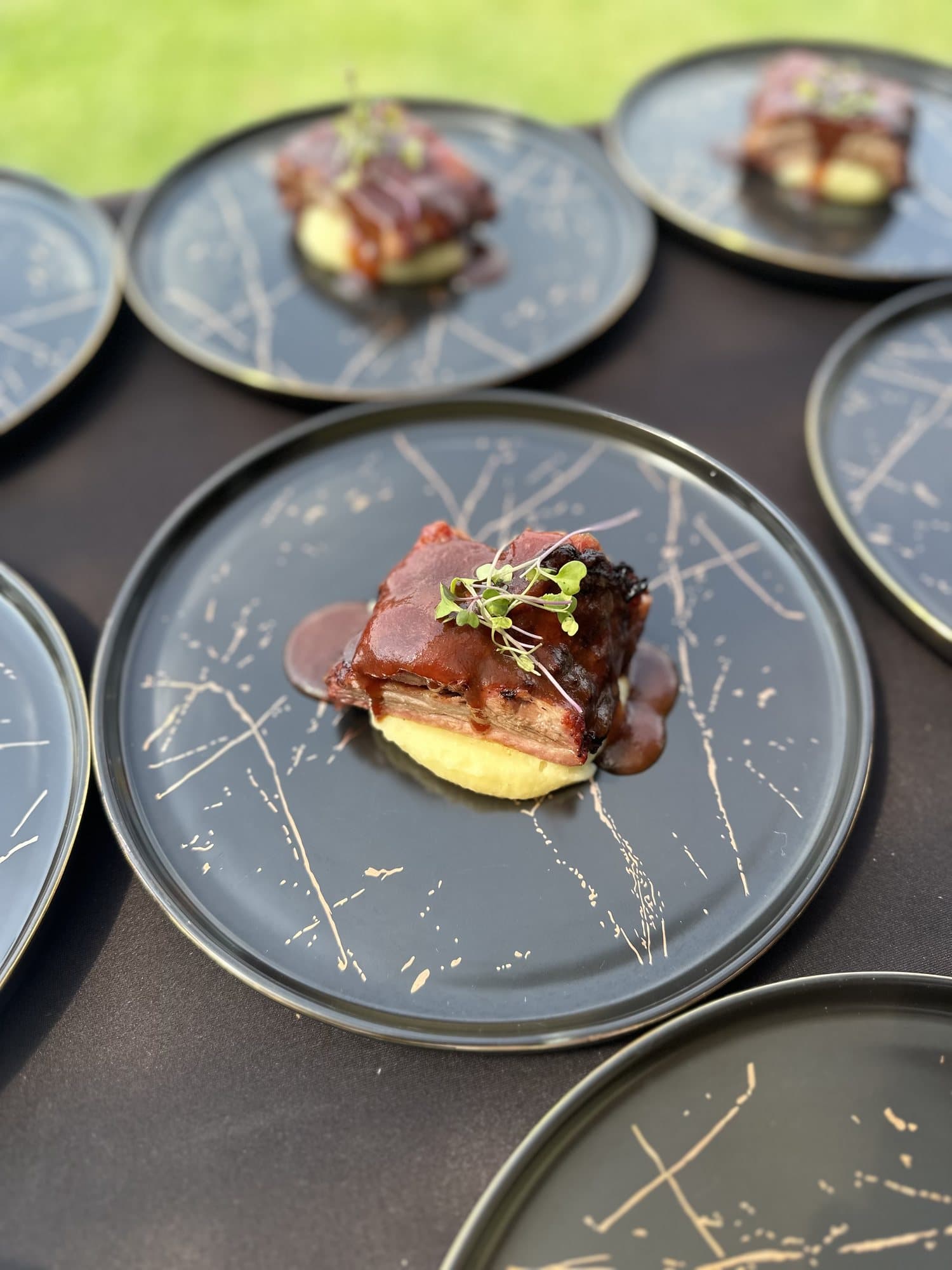 Panceta en salsa BBQ sobre puré, del asado al barril por tiempos